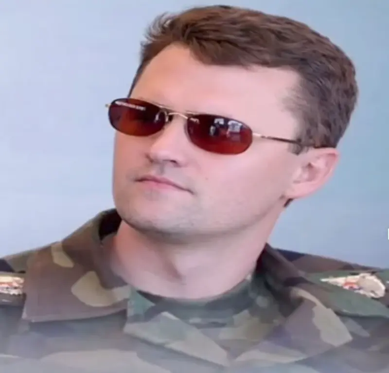 A man in a military uniform and sunglasses.