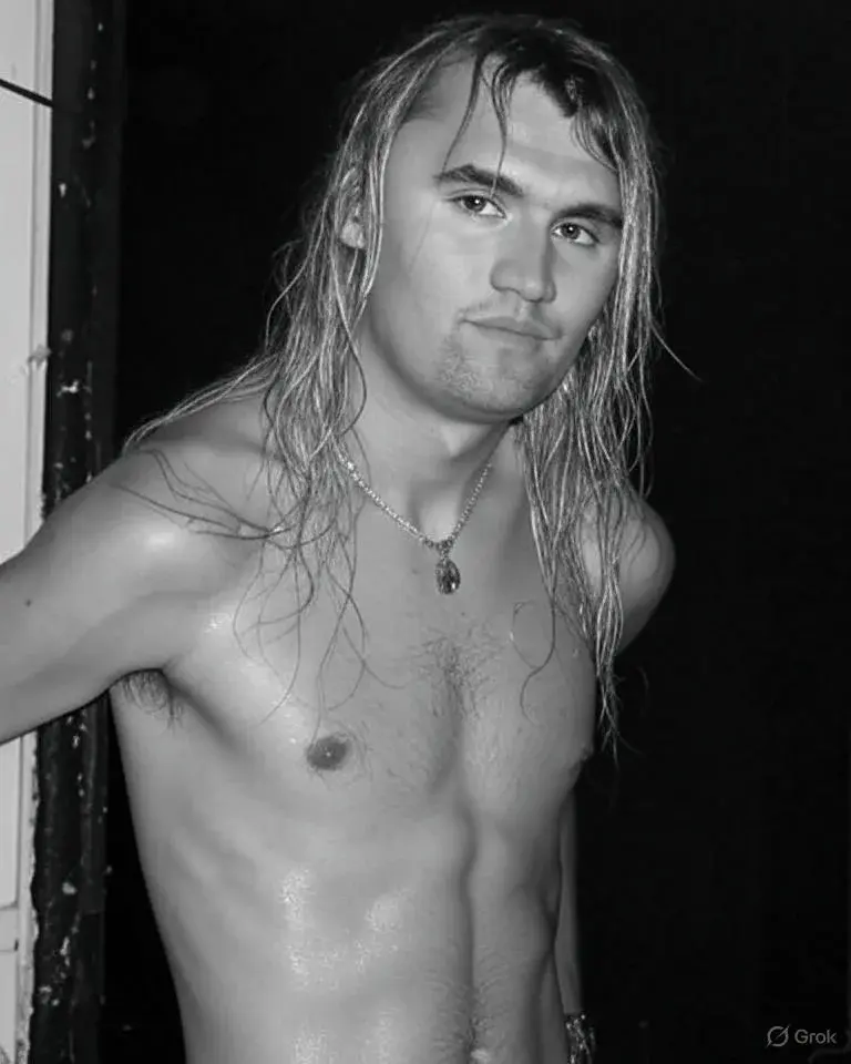 A man with long hair standing in front of a door.