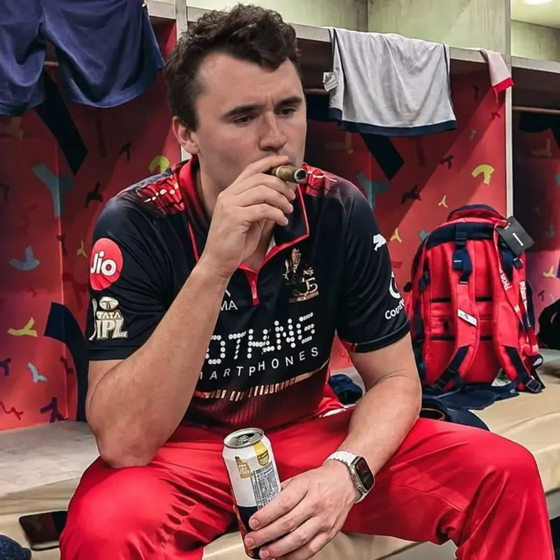 A man sitting on a bench with a drink.