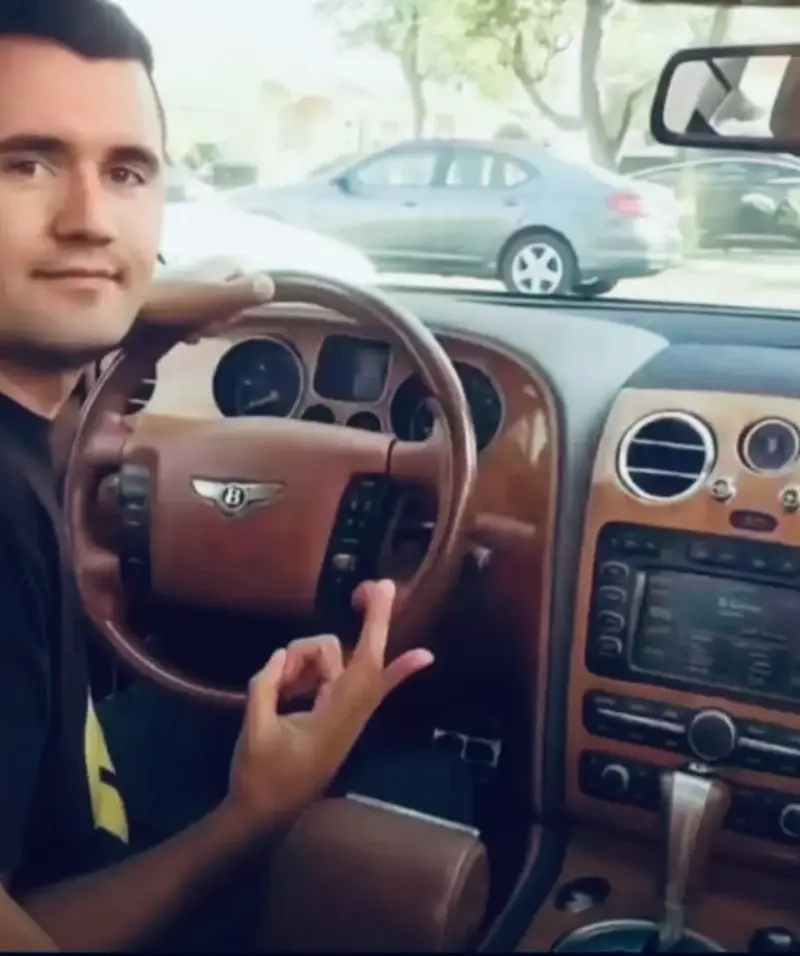 A man sitting in the driver ' s seat of a car.