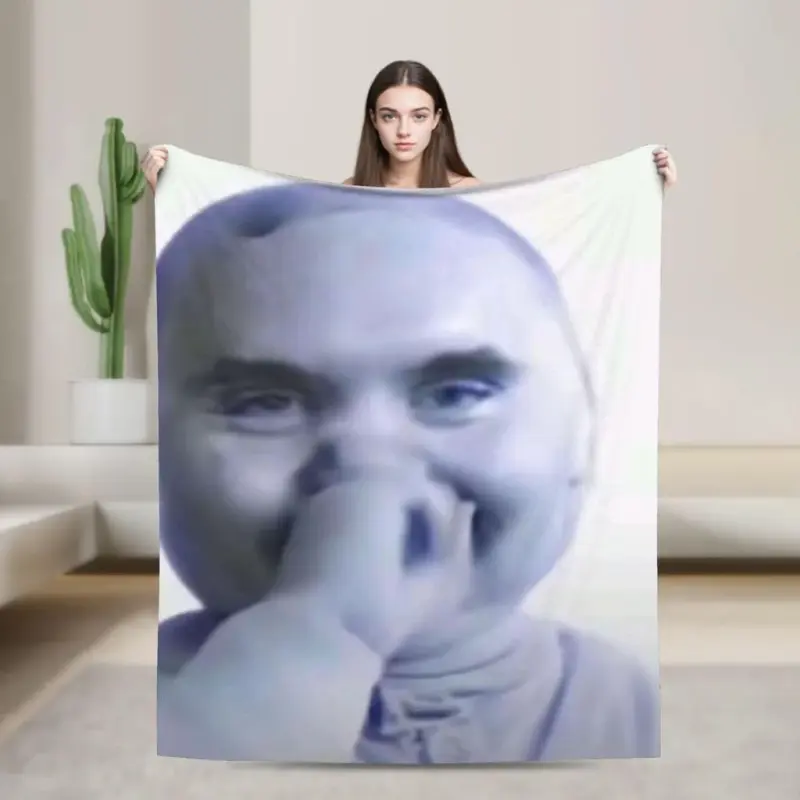 A woman holding a blanket with a photo of a man.
