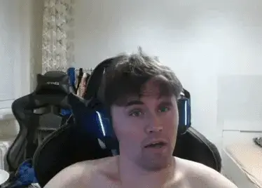 A man with no shirt sitting in a chair.