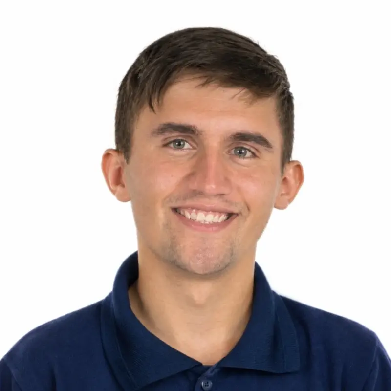 A man in a blue shirt smiles at the camera.