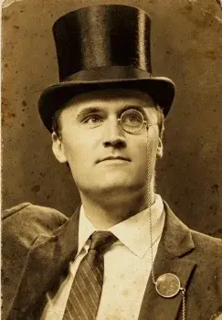 A man in a top hat and tie with a cane.