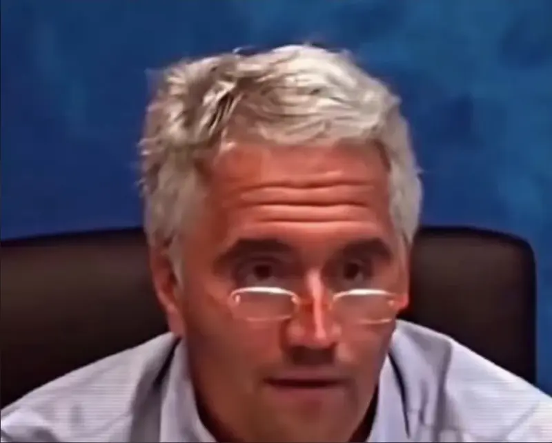 A man with glasses on is sitting in front of a computer.