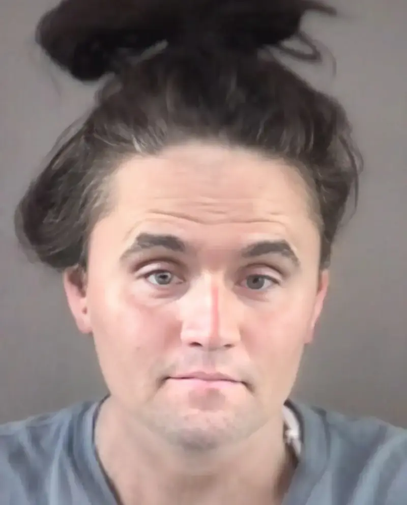 A man with a messy top knot on his head.