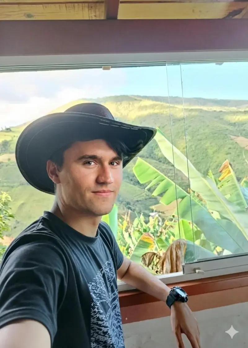 A man in a hat is looking out the window.