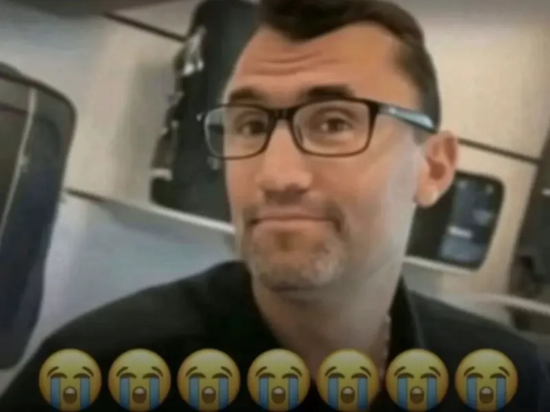 A man with glasses and a black shirt.
