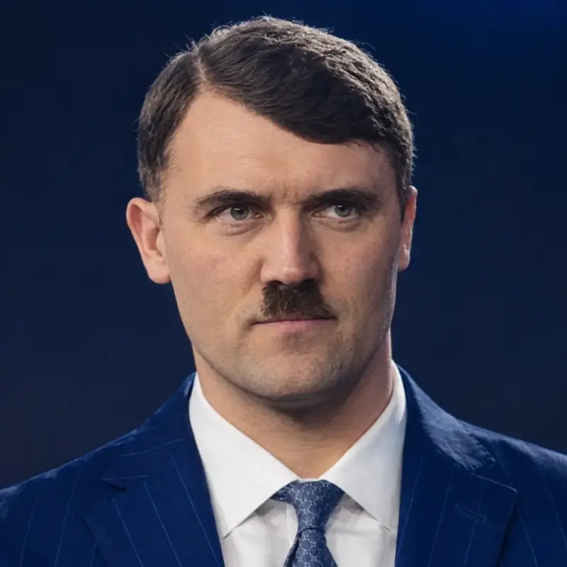 A man in a suit and tie with a mustache.