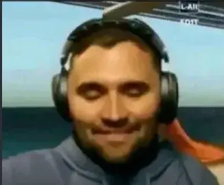 A man in a blue jacket is sitting in a helicopter.