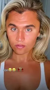 A woman with blonde hair and a white tank top.