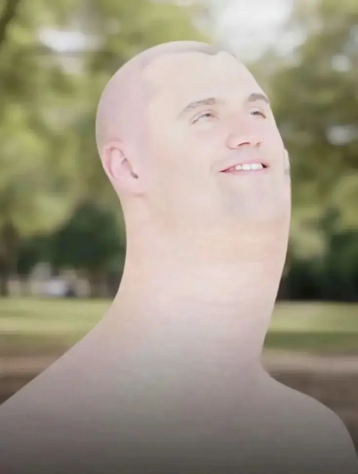 A man with a bald haircut smiles at the camera.