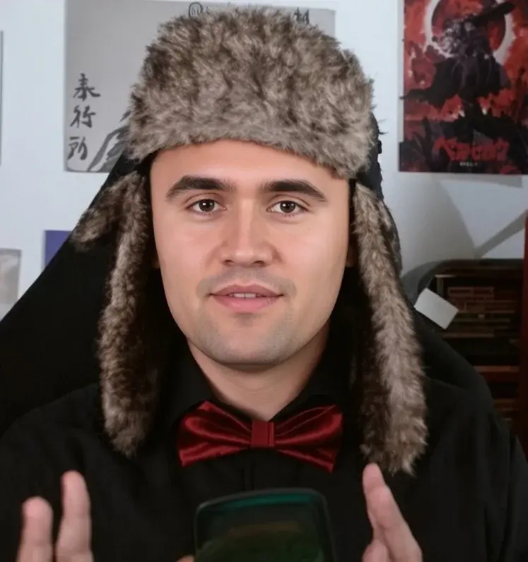A man in a fur hat holding a cell.