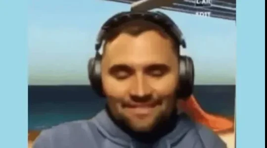 A man wearing headphones and a blue shirt.