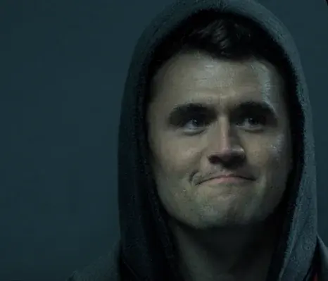 A man in a hoodie looks at the camera.