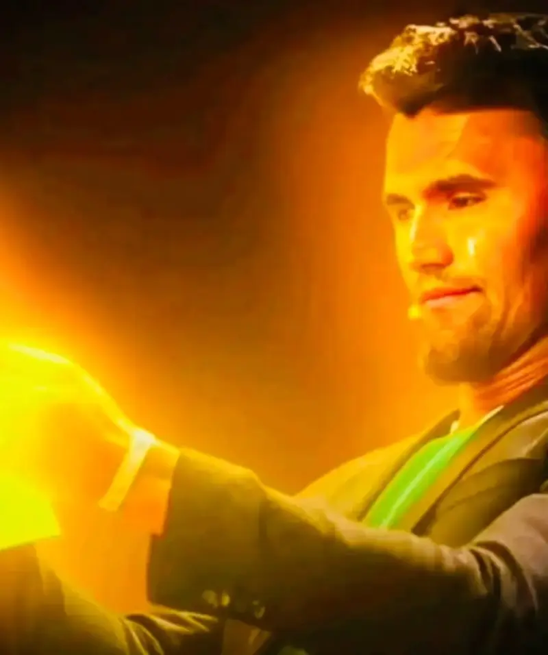 A man in a suit holding a light.