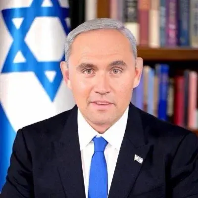 A man in a suit and tie sitting at a desk.